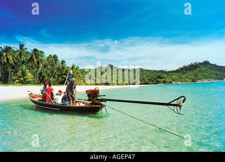 Un tradizionale Thai barca dalla coda lunga con turisti che lasciano Ao Thong Nai Pan Noi beach in Koh Phangan isola della Thailandia Foto Stock
