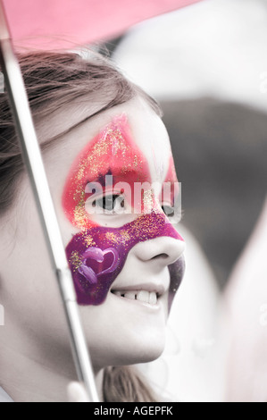 Sorridente ragazza con una farfalla dipinta sul suo viso Foto Stock