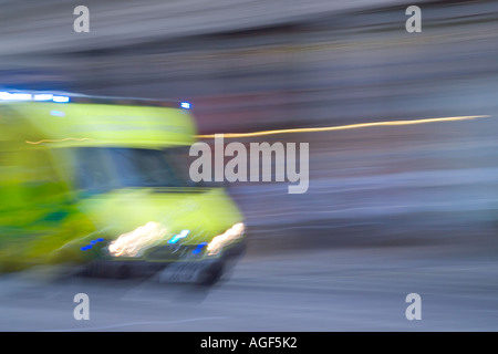 Ambulanza con luce blu lampeggiante luci su strada a EMERGENZA Foto Stock