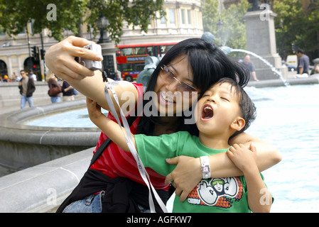 Una famiglia cinese boy e madre turistico è in posa per autoritratto in Trafalgar Square a Londra nel Regno Unito Foto Stock