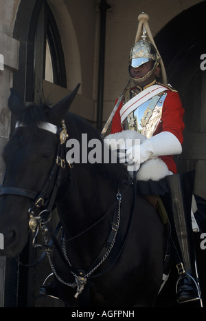 Un membro della vita delle guardie della cavalleria della famiglia siede sul suo cavallo all'ingresso la Horseguards edificio. Foto Stock