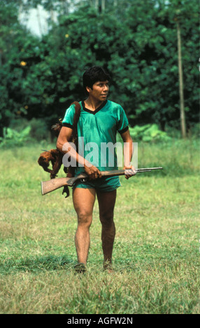 Bolivia Reyes giovane uomo a camminare con la pistola e morti scimmia urlatrice Foto Stock