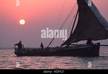 Dhow stagliano contro il sole di setting Stone Town harbour Unguja Zanzibar Tanzania Foto Stock