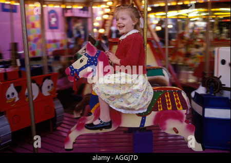 Giostra divertente in una fiera del 1990s UK. Giovane ragazza tradizionale cavallo in legno dipinto a mano buon divertimento Wimbledon Common Londra Regno Unito intorno al 1995 HOMER SYKES Foto Stock