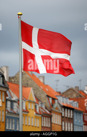 Il danese bandiera nazionale di Nyhavn (nuovo) Porto in Copenhagen, Danimarca Foto Stock