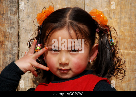 Una giovane ragazza cinese è in posa con fiducia come un modello nella parte anteriore della fotocamera Foto Stock