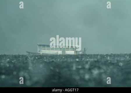 Blue dhoni in barca a vela attraverso heavy rain al largo della costa di Rasdhoo, un'isola disabitata nelle Maldive. Foto Stock