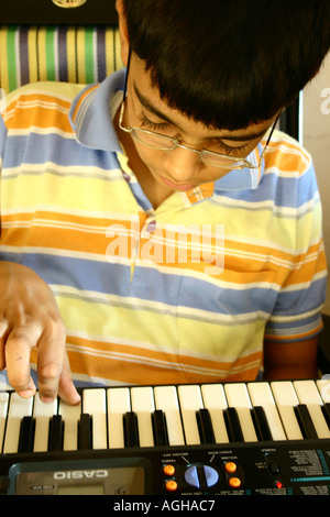 RSC91155 dodici anni vecchio ragazzo di apprendimento di strumenti musicali pianoforte Bombay ora Maharastra Mumbai India Foto Stock