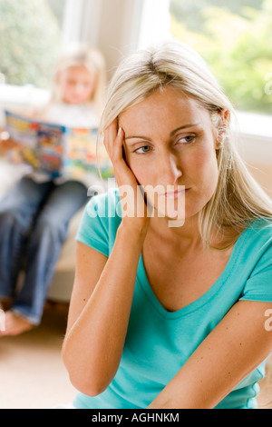 Madre cercando preoccupato con sua figlia in background Foto Stock