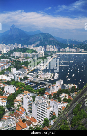 Barche nella baia di Botafogo e alto edificio di appartamenti sotto il monte Corcovado a Rio de Janeiro in Brasile Foto Stock