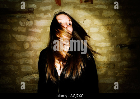 Ritratto di ragazza adolescente vestito di nero in alto e facendo oscillare i suoi capelli a lato. Foto Stock