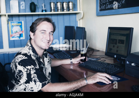 Ritratto di una metà uomo adulto utilizzando un computer Foto Stock