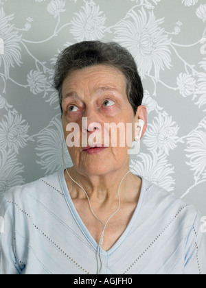 Senior donna ascolto di musica Foto Stock