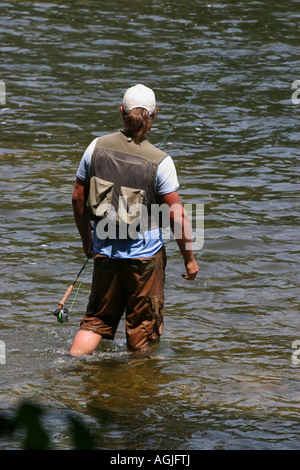 River Little Manistee, mi USA, giovani pescatori di pesca con la mosca, con una canna da vicino, un uomo caucasico si trova nell'acqua indossando un giubbotto da pesca ad alta risoluzione Foto Stock