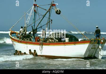 I pescatori di Santa Rosa Perù nord lanciare una barca nel surf in uscita dell'oceano pacifico Foto Stock