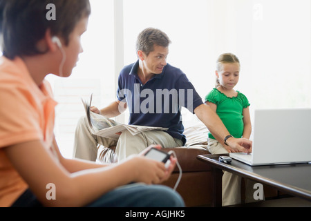 Padre aiutando la figlia uso portatile Foto Stock