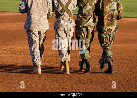 Quattro soldati in military camouflage uniformi marciando in unisono. Foto Stock