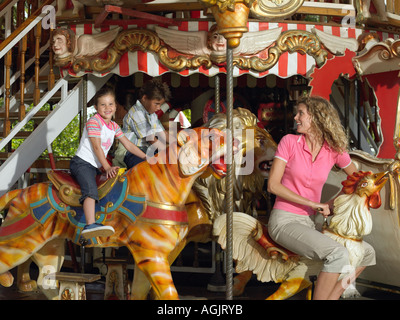 Madre e bambini su una giostra Foto Stock