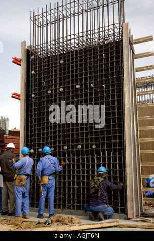 I lavoratori che operano su rebar cemento armato telaio su un edificio sito in costruzione in Abu Dhabi Emirati arabi uniti Foto Stock