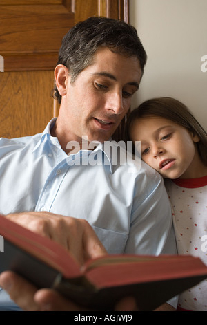 Padre leggendo la Bibbia alla figlia Foto Stock