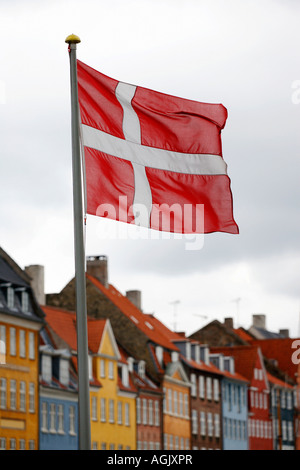 Il danese bandiera nazionale di Nyhavn (nuovo) Porto in Copenhagen, Danimarca Foto Stock