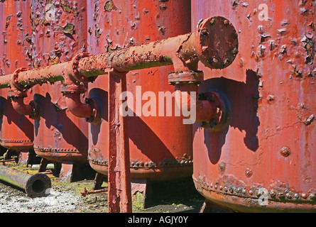 Rosso ruggine dei serbatoi di stoccaggio con i tubi di collegamento Foto Stock