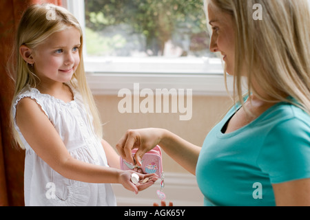 Madre dando sua figlia pocket money Foto Stock