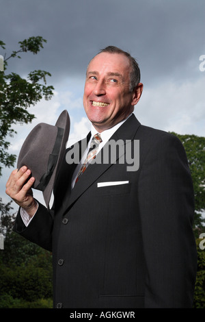 In vecchio stile sfrontato chap tenere un cappello Foto Stock