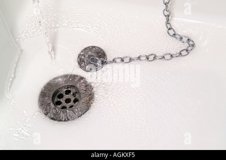 L'acqua verso il basso scarico lavabo bianco Foto Stock