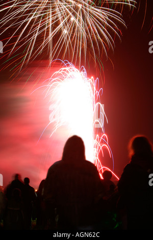 La folla di gente stagliano contro di fuochi d'artificio Foto Stock