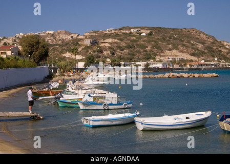 Dh Kamari Kamari Bay Grecia KOS uomo pesca dal molo barche ancorate nella baia angling Foto Stock