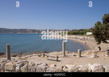 Dh Agois Stefanos Kamari Bay Grecia KOS St Stephens Chiesa pilastro rovine e spiaggia di sabbia Foto Stock