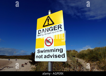 Una nuotata in un segno di avvertimento sulla spiaggia di FINDHORN,Scozia.UK,BRITISH Foto Stock