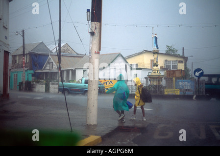 Basseterre St Kitts bambini sulla strada di ritorno da scuola acquazzone tropicale Foto Stock