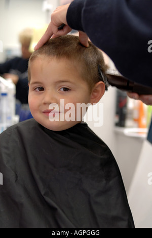 Un giovane ragazzo di ottenere un taglio di capelli Foto Stock