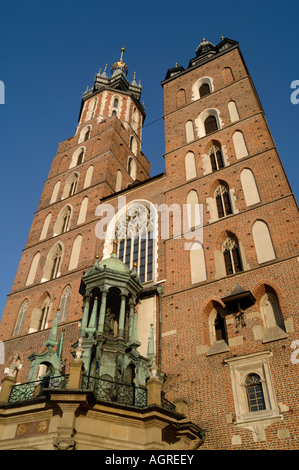 Le guglie di Krakows chiesa Mariacki salire al di sopra del panno Sukiennice Hall sulla Piazza del Mercato Principale Foto Stock