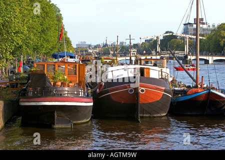 Battelli ormeggiato sul fiume Amstel di Amsterdam Paesi Bassi Foto Stock