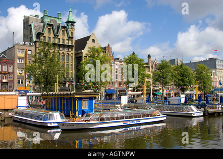 Tour battelli sul Damrak canal in Amsterdam Paesi Bassi Foto Stock