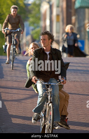 La gente in bici su strada ad Amsterdam Paesi Bassi Foto Stock