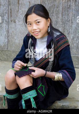 Giovane ragazza Hmong cucito indossando il tradizionale Hill Tribes abbigliamento vicino a Sapa Vietnam. Foto Stock
