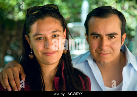 Uomo ispanico (circa 32 anni) e la donna (circa 31 anni) seduta su una panchina nel parco Foto Stock