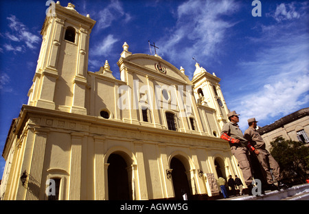 Due agenti di polizia pattugliano di fronte alla cattedrale di Asunción, situata in Plaza de la Independencia, Paraguay. Foto Stock