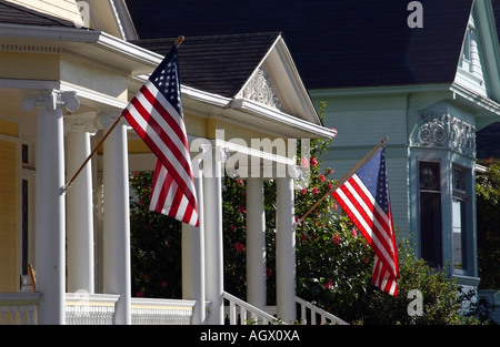 Una bandiera americana si blocca su un portico di una piccola città home Foto Stock