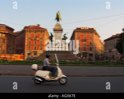 In rapido movimento di ET4 scooter Vespa nel cerchio di traffico con il monumento a Garibaldi Milano Italia Foto Stock