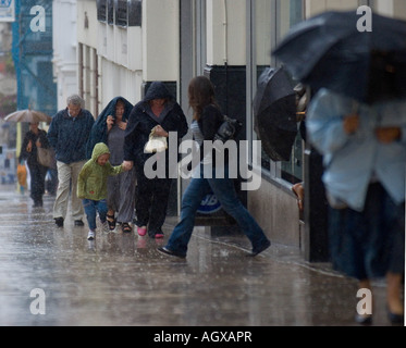 Estate Meteo piogge torrenziali che hanno spazzato attraverso la parte centrale dell'Inghilterra oggi PIC MOSTRA GLI ACQUIRENTI catturati in una tempesta sulla PARADE LEAMINGTON Foto Stock