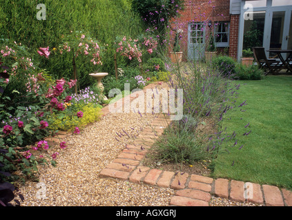 Percorso di mattoni di ghiaia piccolo giardino sul retro design Prato casa fiore di confine siepe sempreverde Foto Stock