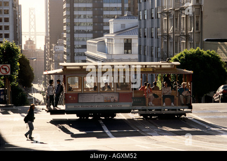 San Francisco, CA, Stati Uniti d'America, cavo auto su Powell Street attraversamento California Street, il Bay Bridge in distanza, mattina Foto Stock