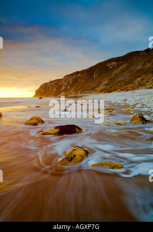 Mare lavato massi sulla spiaggia di sabbie speeton nr filey con scogliere buckton nella distanza Foto Stock