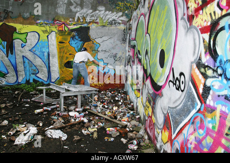L'uomo la spruzzatura di graffiti su una parete Foto Stock