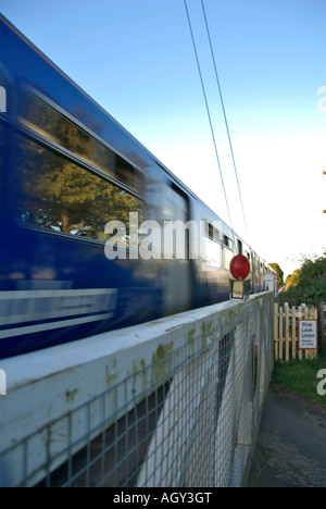 Treno che attraversa un passaggio a livello Foto Stock